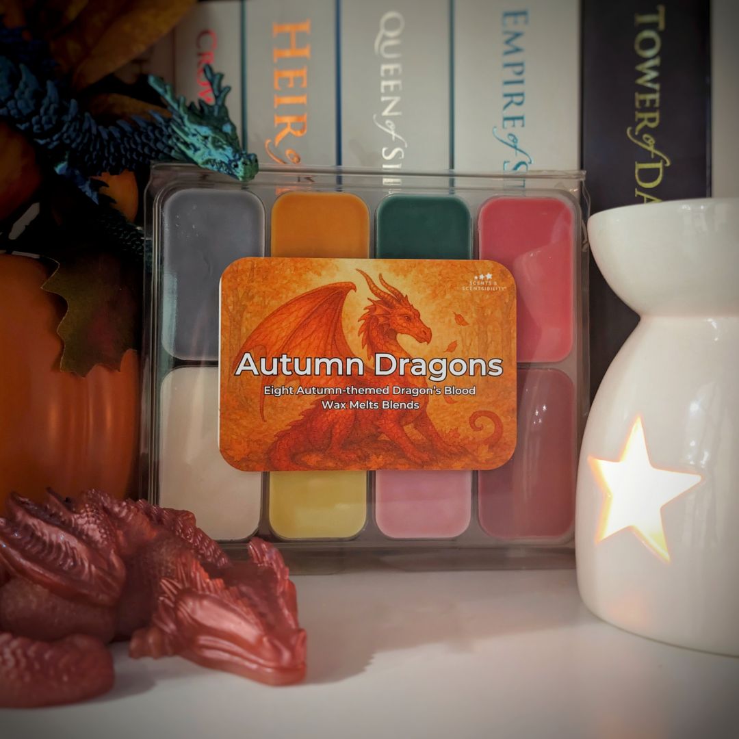 Pack of 'Autumn Dragons' wax melts with decorative dragon figures and a lit candle in the background.