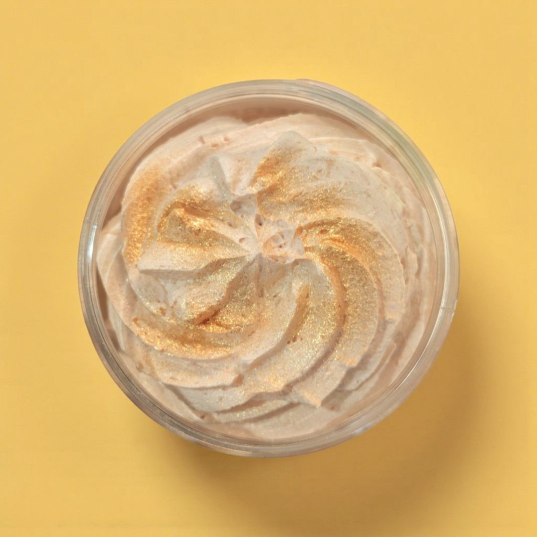 Jar of whipped soap with gold and silver swirled texture on a yellow background