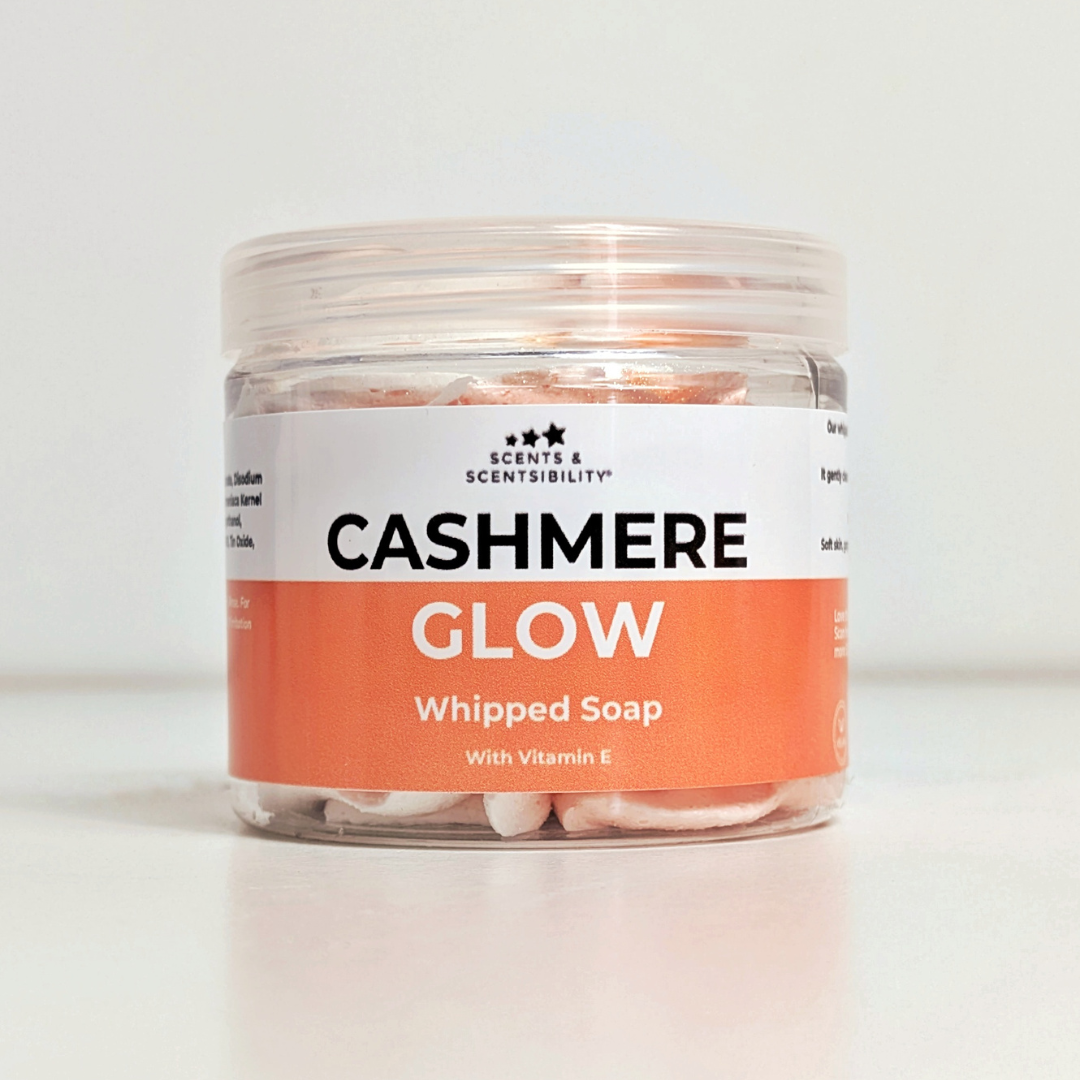 Jar of 'Cashmere Glow' whipped soap with a peach and white label on a white background