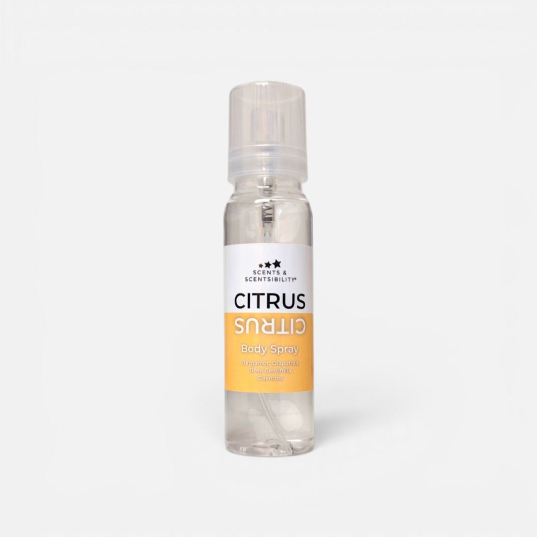 Clear bottle of citrus body spray on a white background