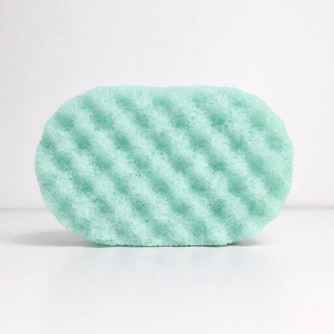 Green sponge with wavy texture on a white background