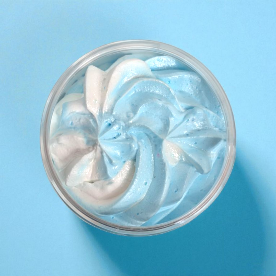 Blue and white Coconut Bay whipped soap in a clear container on a blue background