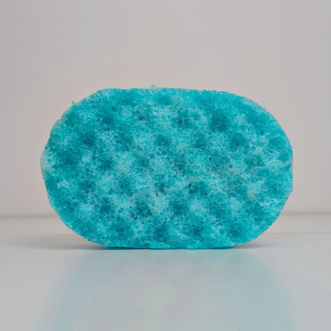 A textured, teal-coloured soap-soaked sponge.