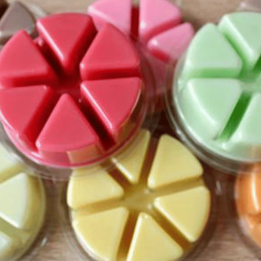 A colourful pile of wax melts, each with 6 segments in a recyclable pot