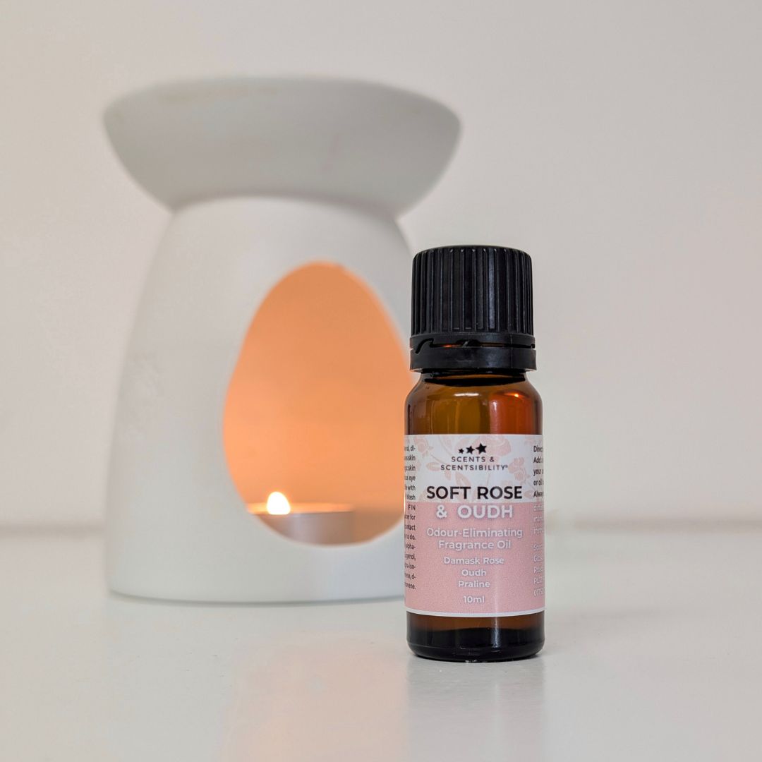 Bottle of 'Soft Rose & Oudh' fragrance oil with an oil burner in the background