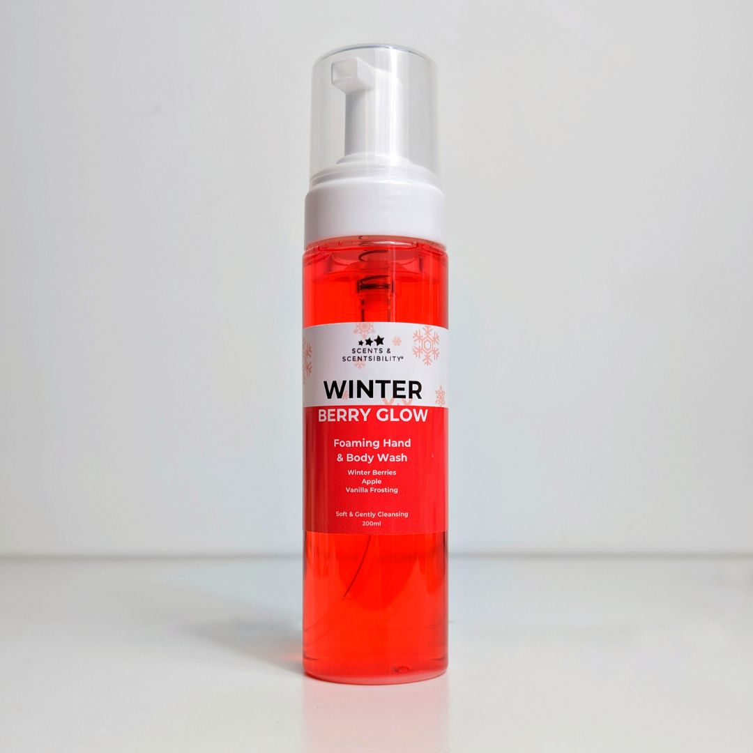A tall bottle of red liquid soap with a foamer top and labelled 'Winter Berry Glow'