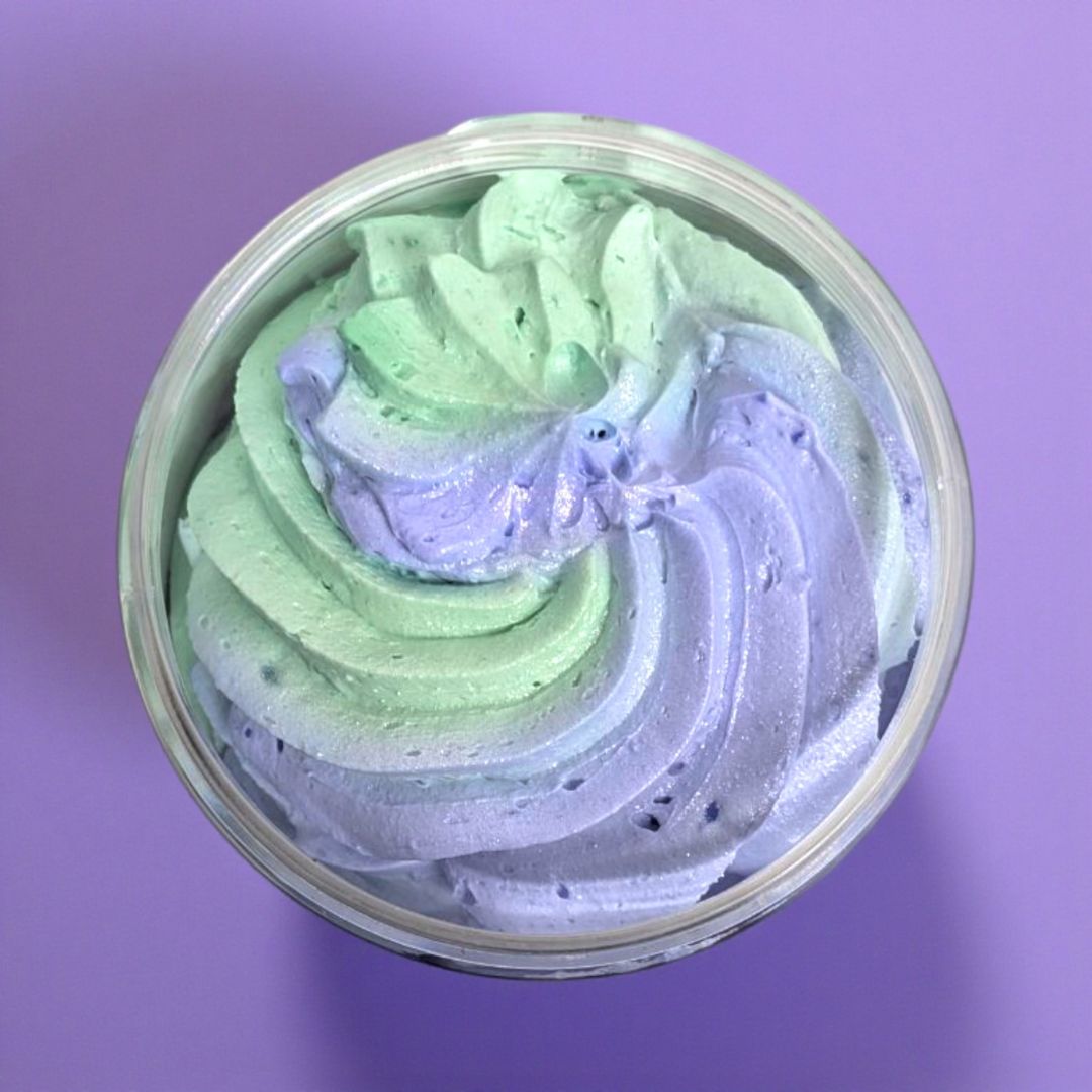 Top view of a container with green and purple swirled soap on a purple background