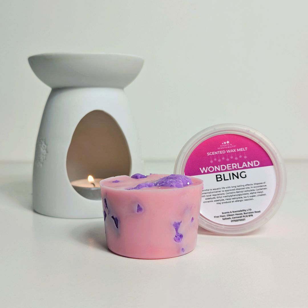 Pink and purple scented wax melt with a white wax melt burner and container on a light background