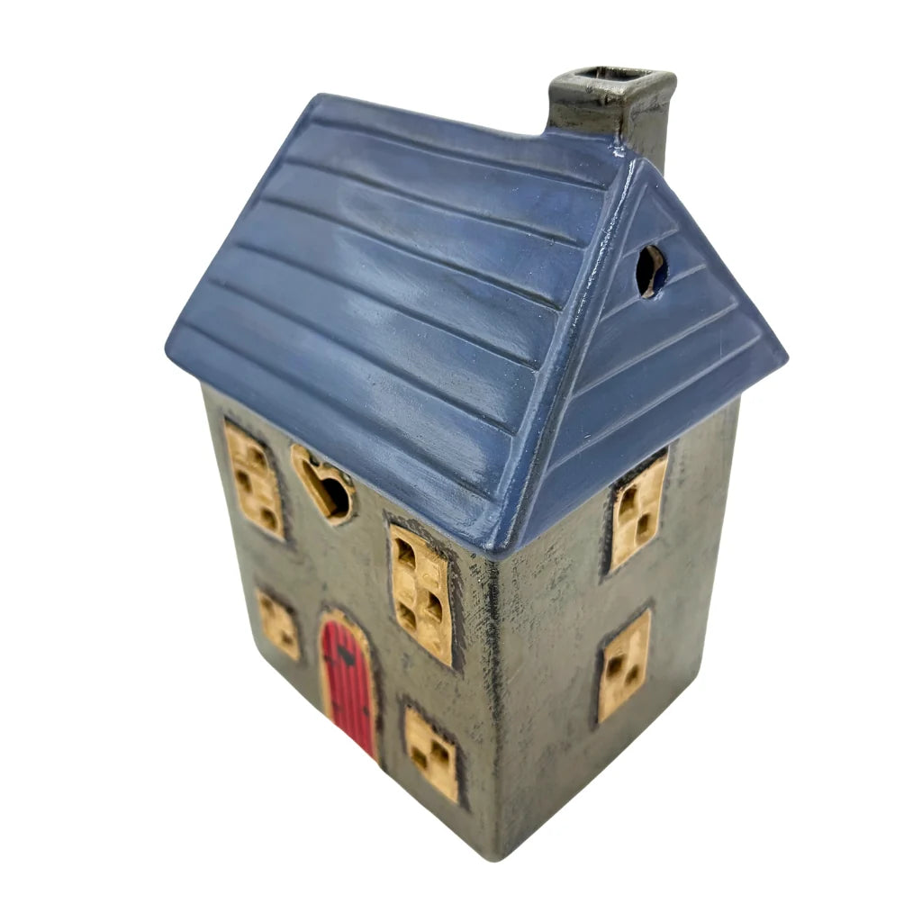 Ceramic house-shaped wax melt warmer with blue roof and red door on a white background