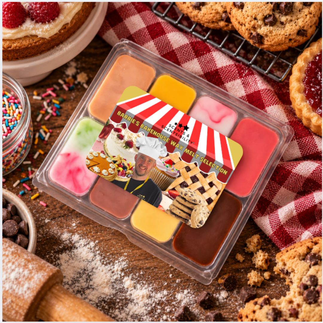 A clear plastic scented melt tray with multiple colorful wax sections and a branded lid label, styled on a wooden surface with cookies, sprinkles, and a red gingham cloth.