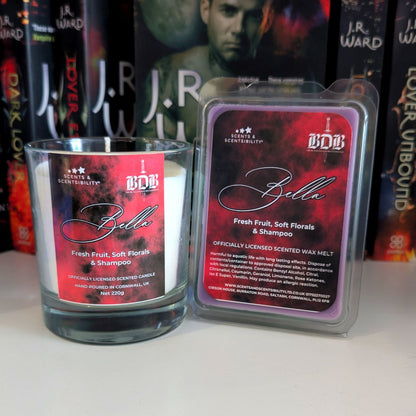 Scented candle and wax melt packaging with 'Bella' branding in front of J.R. Ward book covers.