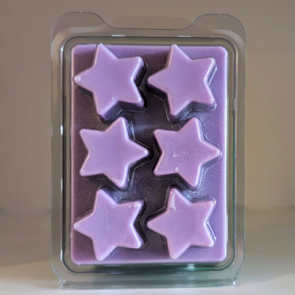 Purple star-shaped wax melts in a clear plastic mold on a beige background
