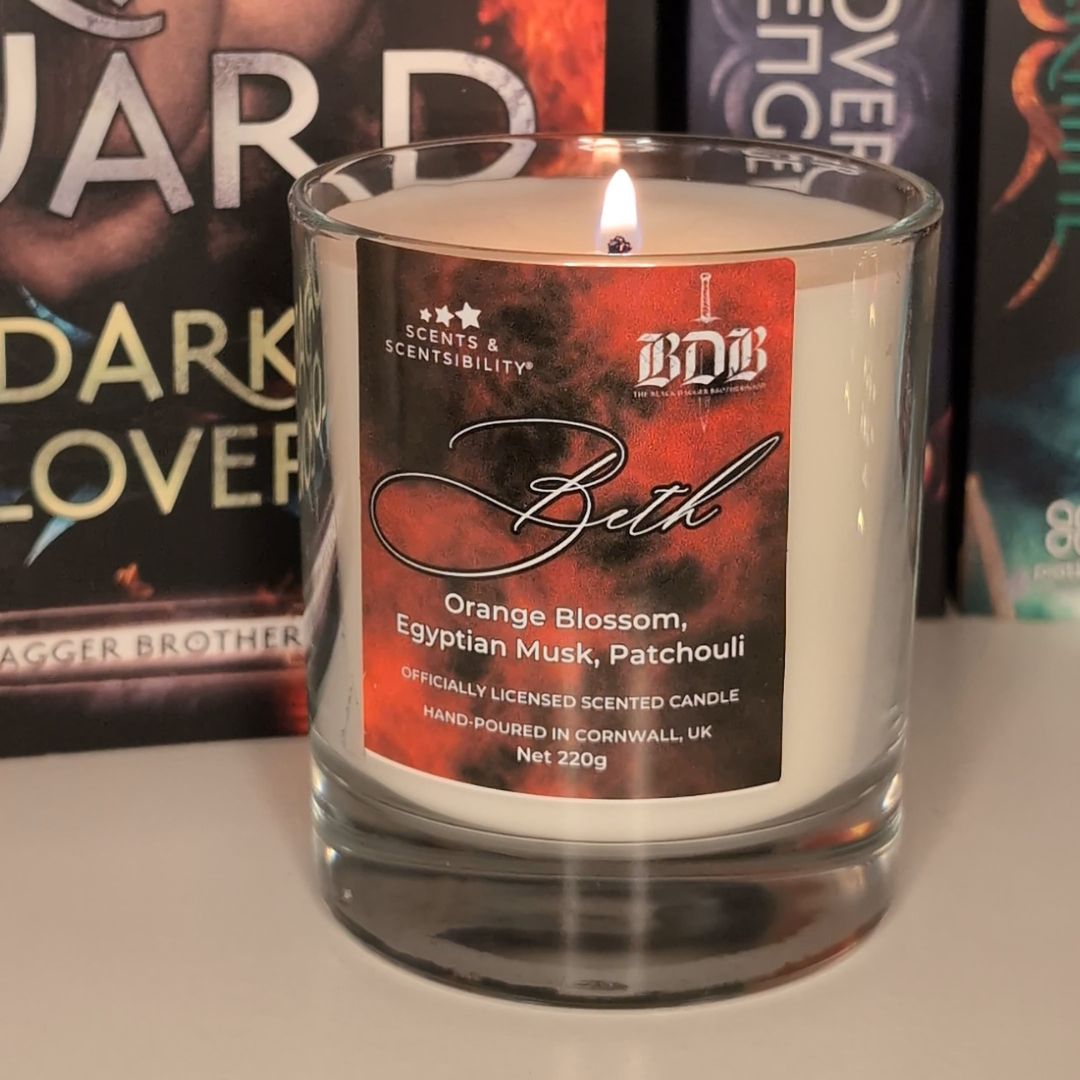 Candle with a red label saying Beth in front of a book called Dark Lover by J R Ward