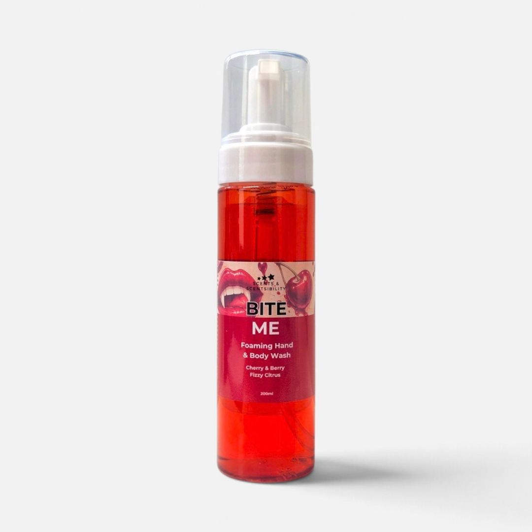 A bottle of Bite Me Foaming Hand & Body Wash, featuring a translucent red liquid and a white pump dispenser, set against a light grey background.