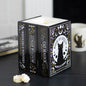 Decorative wax melt and oil burner with book design featuring a black cat on a dark surface.
