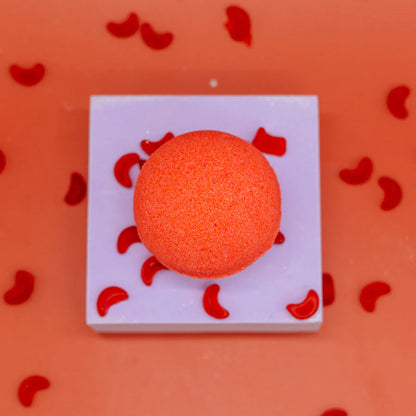 A red bath bomb on a white surface