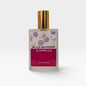 A bottle of perfume with a gold cap and dark red label with berries and vanilla, saying 'Black Raspberry & Vanilla'