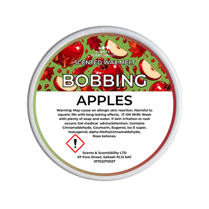 A round tub of Scents & Scentsibility Scented Wax Melt in the 'Bobbing Apples' fragrance, featuring a green and red apple-patterned label with a white warning panel at the bottom.