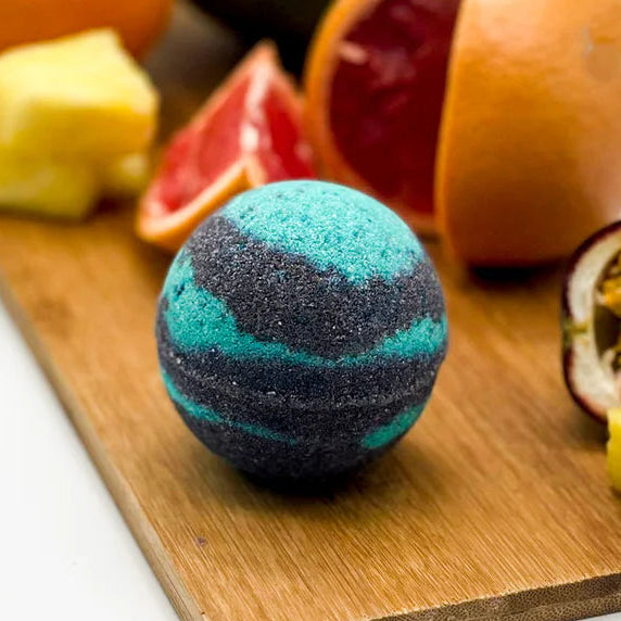 Bath bomb on a wooden board with fruits in the background