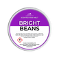 A Scents & Scentuality 'Bright Beans' scented wax melt, featuring a purple and white label with product details and a warning symbol, set against a solid dark green background.