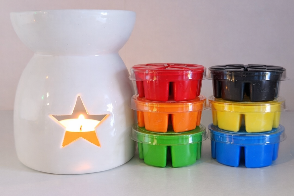 White wax warmer with colourful wax melts on a light background