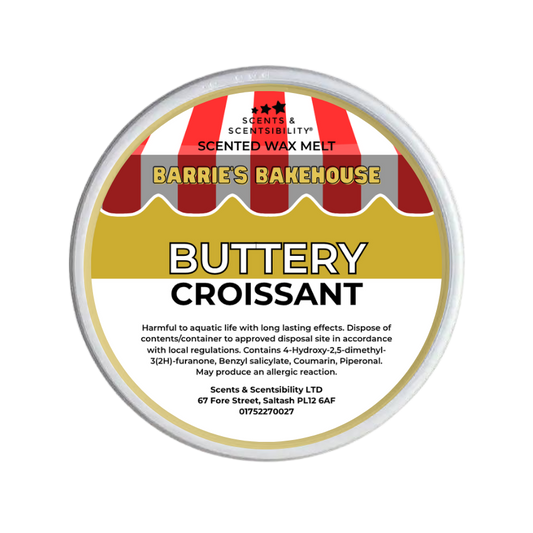 A round metal tub of Scents & Scentsibility 'Buttery Croissant' scented wax melt by Barrie's Bakehouse, featuring a label with red and white striped bakery awnings and yellow and white text.