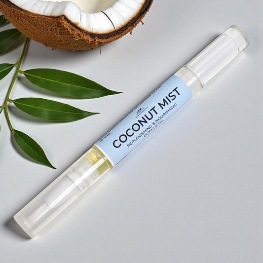 Coconut mist cuticle pen with a half-coconut and leaves on a light gray background