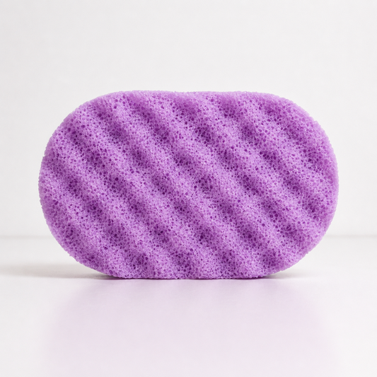 A purple coloured, textured sponge on a white background