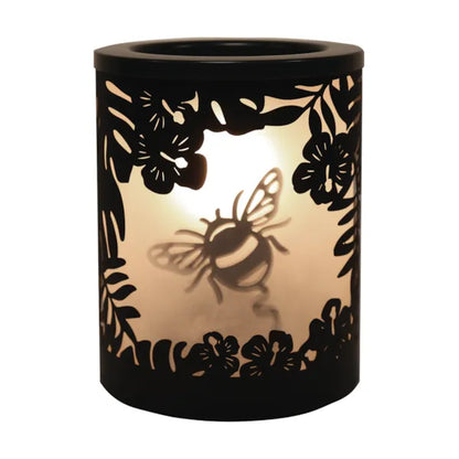 A black wax melt warmer with glowing light and bumble bee silhouette design on a white background