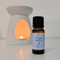 Bottle of 'Ever After' fragrance oil with a lit wax warmer in the background