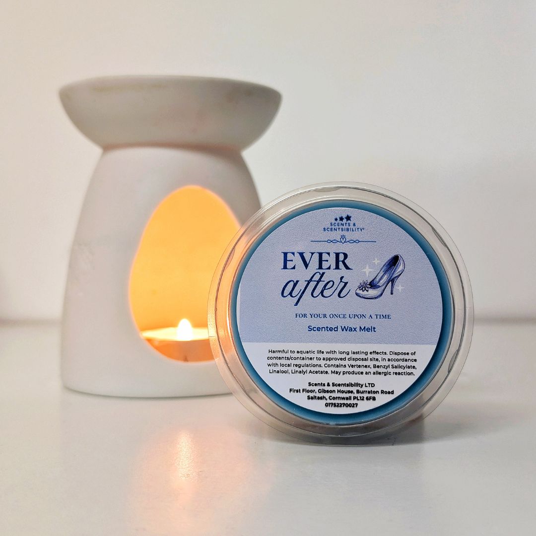 Scented wax melt container labeled 'Ever After' with a lit candle in the background.