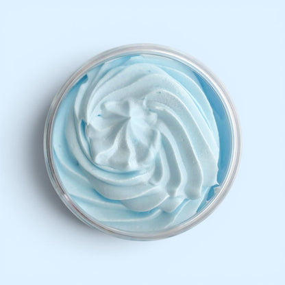 Close-up of a swirl of blue and white whipped soap in a container on a light blue background
