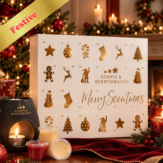 Scents & Scentibility Merry Scentmas Advent Calendar box displayed on a festive Christmas table with candles, ornaments, and holiday decorations in the background.