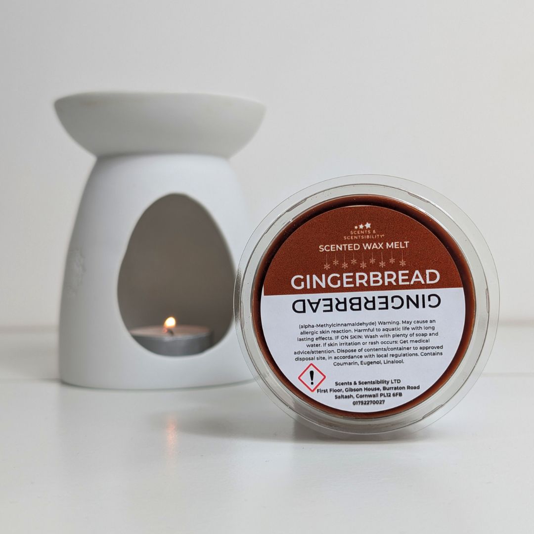 Scented wax melt container labeled 'Gingerbread' with a white wax warmer in the background.