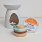 Scented wax melt with packaging labeled 'Gone Pumpkin Picking' next to a wax warmer.