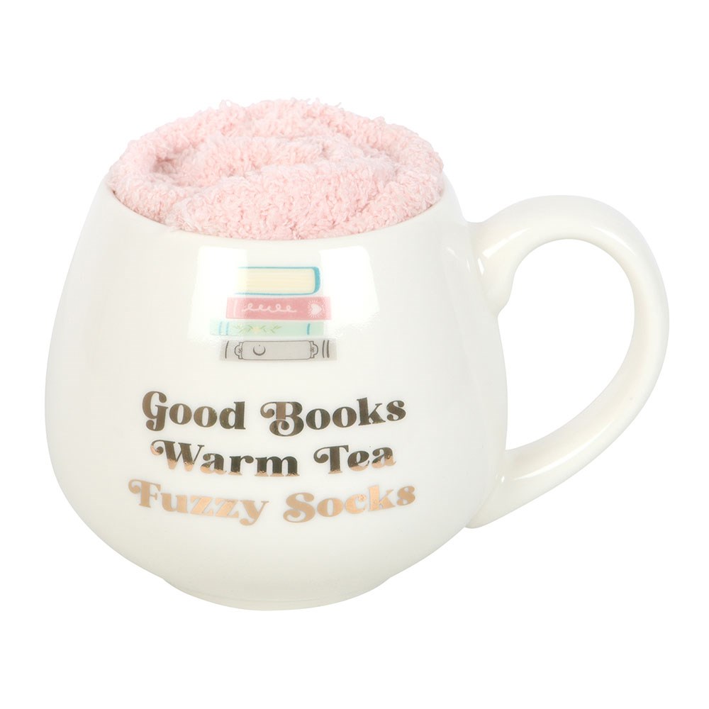 White mug with pink fuzzy interior, text 'Good Books Warm Tea Fuzzy Socks', and a small flag design.