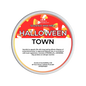 A round tub of Scents & Scentsibility 'Halloween Town' scented wax melt, featuring a red, white, and orange label with candy graphics.