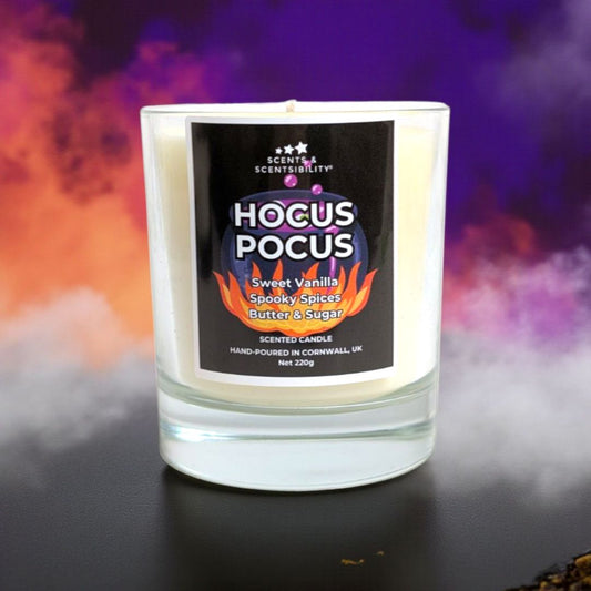 Candle with 'Hocus Pocus' label against a colorful, smoky background