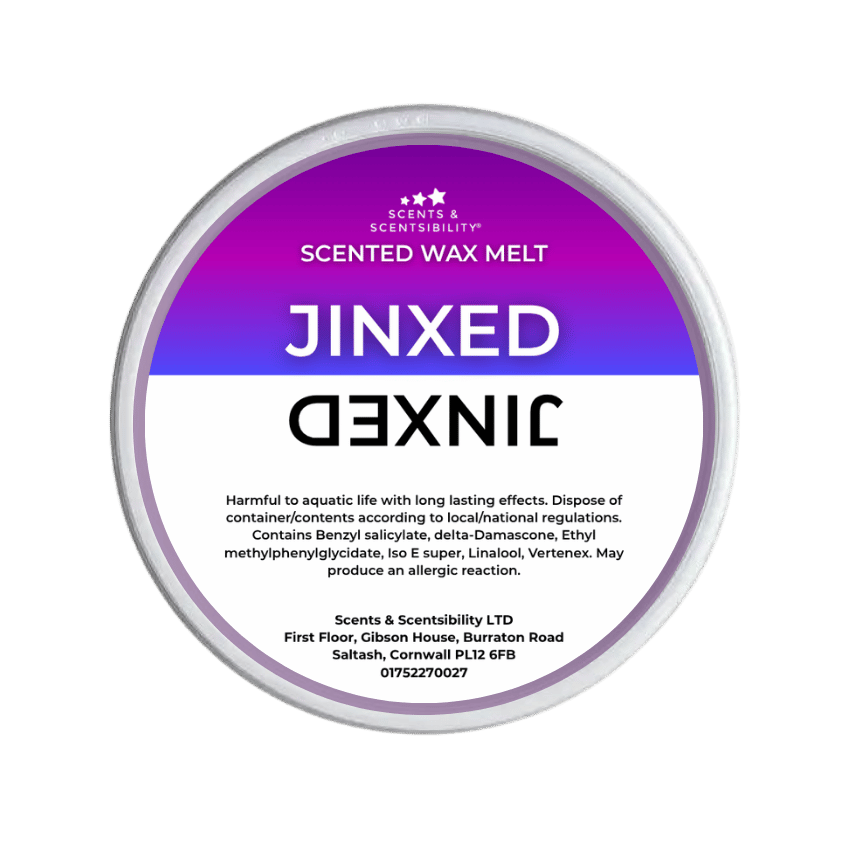 A Jinxed Scented Wax Melt by Scents & Scentsibility, featuring a purple-to-white gradient label with bold white text, shown against a solid dark green background.