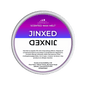 A Jinxed Scented Wax Melt by Scents & Scentsibility, featuring a purple-to-white gradient label with bold white text, shown against a solid dark green background.
