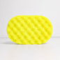 A textured, yellow sponge, filled with soap on a white background