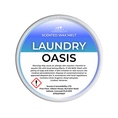 A round white plastic tub of Scents & Scentsibility 'Laundry Oasis' scented wax melt, shown against a solid dark green background.