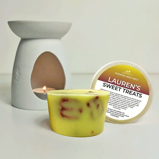 Scented wax melt with packaging labeled 'Lauren's Sweet Treats' and a wax warmer in the background.