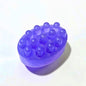 Purple oval massage soap bar with raised textured bumps on a white background.