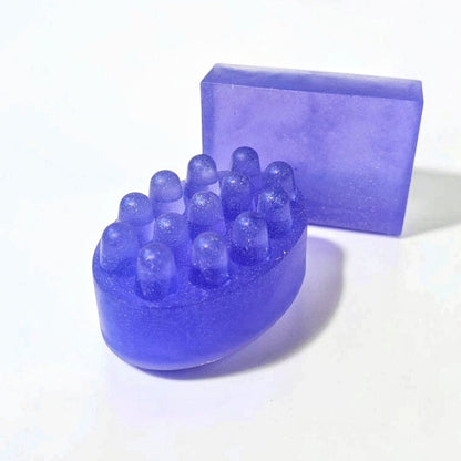 Purple massage soap bar with raised massage bumps alongside a matching rectangular soap bar.