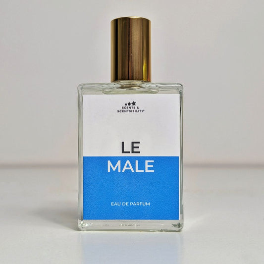 A glass perfume bottle with gold cap and blue and white label saying 'Le Male'