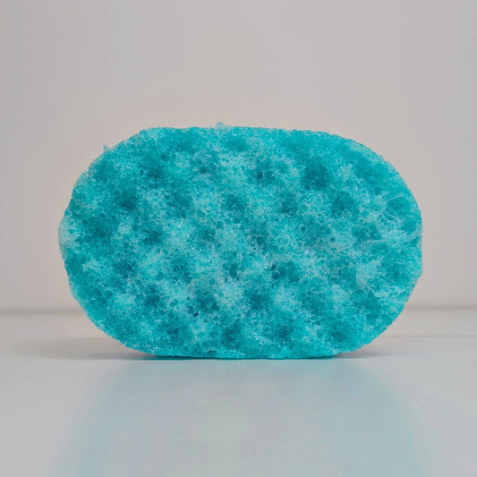 A textured, teal-coloured soap-soaked sponge. 