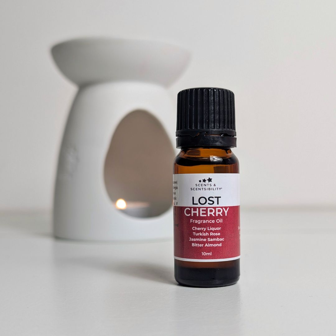 Bottle of Lost Cherry fragrance oil with an oil burner in the background