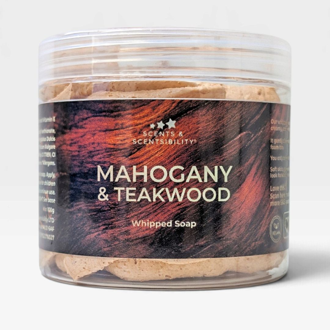 A clear plastic jar of Scents & Scentsibility 'Mahogany & Teakwood' Whipped Soap, showing the light brown whipped soap inside with a dark wood-grain label.