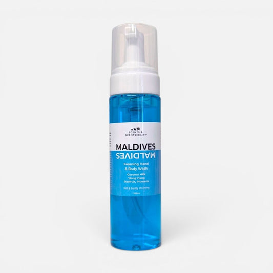 A bottle of Maldives Foaming Hand & Body Wash with bright blue liquid soap, a white pump dispenser, and a white label, set against a plain light gray background.